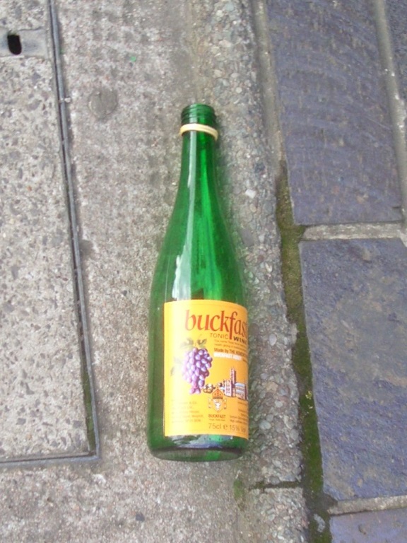 Photo of an empty bottle of Buckfast Tonic Wine (Bucky) in a Glasgow street
